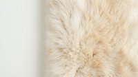 Soft beige faux fur texture with fluffy fibers creating luxurious tactile surface for interior design and fashion applications.