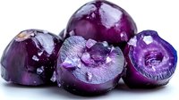 Fresh purple potatoes cut in half showing vibrant interior flesh with crystalline texture on white background, macro food photography for healthy eating concepts.