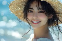 Young Asian woman with radiant smile wearing straw hat against blurred summer beach background, natural beauty with windswept hair and glowing skin.