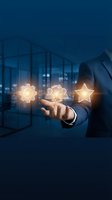 Businessman in dark suit holding glowing gear, people, and star icons above palm against modern office interior. Represents business growth, teamwork, success, and performance management.