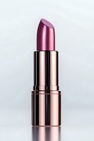 Metallic rose gold lipstick in luxury packaging isolated on light background with reflection, ready for cosmetic advertising and beauty campaigns.
