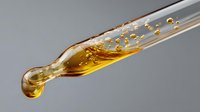 Golden liquid with bubbles splashing and dripping from glass tube against gray background, macro photography capturing dynamic fluid motion in laboratory setting.