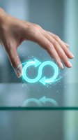 Hand holding glowing cyan infinity symbol with arrows and particle effects above glass surface, representing continuous cycle, renewable energy, sustainable business, circular economy concepts.