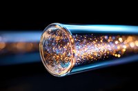 Glowing optical fiber with golden sparkles and bokeh effects against dark background, modern telecommunications technology and data transfer concept.
