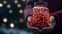Glowing fairy lights in mason jar held by hands against dark background with bokeh lights creating magical, cozy atmosphere. For holiday decor and celebrations.