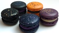 Colorful galaxy-themed macarons with star decorations on white background, isolated dessert treats for bakery and confectionery design projects.