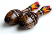 Wooden maracas with colorful feather details and intricate ethnic patterns on dark background, traditional Latin American musical percussion instruments for folk music performance.