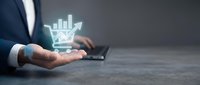 Businessman holding glowing shopping cart with bar chart icon representing e-commerce growth, digital marketing analytics and online retail success metrics.