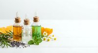Natural essential oil bottles with herbs and flowers for aromatherapy spa wellness treatment on white background.