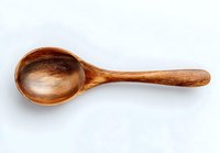 Handcrafted wooden spoon with rich brown tones and natural grain pattern on white background, perfect for rustic kitchen decor and cooking photography.