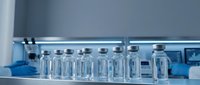 Medical laboratory glass vials with metal caps arranged on sterile surface for pharmaceutical research and drug development testing procedures.