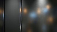 Modern dark metal panel with vertical seam dividing frosted glass surface featuring warm and cool bokeh light reflections for contemporary design backgrounds.