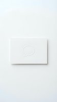 Minimalist white card with embossed speech bubble icon on neutral background, suitable for communication, messaging, dialogue, and business branding design projects.