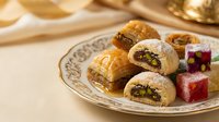Middle Eastern baklava pastries with nuts and Turkish delight on ornate plate. Traditional desserts for celebrations, holidays, and cultural cuisine presentations.