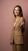 Professional businesswoman in brown suit extending welcoming hand gesture on pink background for corporate marketing and business presentations.