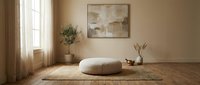Minimalist meditation room with floor cushion on woven mat, neutral beige walls, natural light from window, abstract wall art, potted plant and decorative vase.