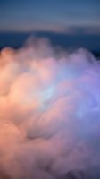 Dreamy pastel clouds in soft pink and purple hues floating against twilight sky creating ethereal atmospheric background for meditation and wellness content.