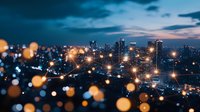 Modern cityscape at dusk with glowing bokeh lights in foreground, illuminated skyscrapers and dramatic blue sky with clouds creating atmospheric urban scene.