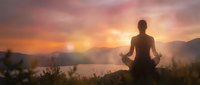 Woman meditating in lotus pose at sunrise with mountains and lake backdrop. Peaceful morning yoga practice for wellness and mindfulness concepts.