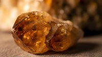 Amber gemstones with warm golden-brown translucent surfaces and natural crystalline formations, suitable for jewelry design, geology education, and luxury product photography.
