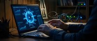 Cybersecurity expert analyzing virus threats on laptop computer in dark office environment with glowing blue malware visualization on screen.