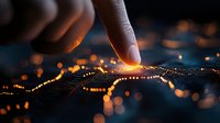 Finger touching glowing circuit board pattern with orange light trails and bokeh effects against dark background, creating futuristic technology concept.