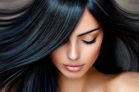 Young Asian woman with long flowing dark hair highlighted with blue tones, closed eyes and natural makeup showing serene expression. Suitable for beauty and haircare advertising.