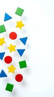 Colorful geometric shapes scattered on white background with copy space for educational materials and children learning activities.