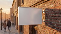 Blank white rectangular sign mounted on red brick wall in urban street setting with warm golden hour lighting and pedestrians walking in background.