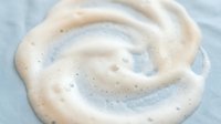 Creamy white sourdough starter with active bubbles showing fermentation process for homemade bread baking and artisan cooking projects.