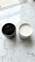 Two ceramic bowls with contrasting black and white contents sit on a marble countertop near a bright window, representing balance and comparison for design or product concepts.