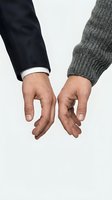 Two hands reaching toward each other in business suit and knit sweater sleeves against white background symbolizing connection, partnership and unity.