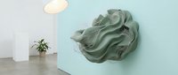 Sage green fabric draped on turquoise wall with minimalist interior design elements including potted plant and pendant light for modern home decor.