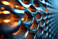 Abstract metallic honeycomb structure with warm orange lighting creating depth and dimension for modern technology and industrial design concepts.