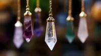 Mystical crystal pendulums hanging on golden chains against dark background, featuring amethyst, clear quartz and other healing stones in pointed shapes.