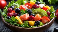 Fresh mixed fruit salad with berries, kiwi, and greens in wooden bowl on rustic table for healthy eating and nutrition concepts.