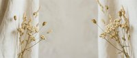 Delicate dried wildflowers arranged on soft beige linen fabric creating minimalist botanical composition for natural home decor and organic design projects.