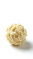 Sphere made of curved pasta shapes arranged in organic pattern against white background, suitable for food and culinary design projects.