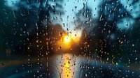 Dramatic sunset view through rain-covered window glass with water drops creating natural bokeh effect. Golden sun rays pierce through stormy weather.