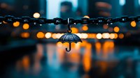 Decorative umbrella pendant on string lights with blurred bokeh city lights in rainy evening atmosphere creating moody teal and orange urban ambiance.