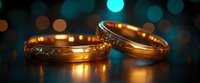 Golden wedding rings with delicate diamond accents on dark background with turquoise bokeh lights creating romantic atmosphere for marriage celebration.