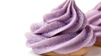 Purple frosting swirl with sparkles on cupcake base isolated on white background for bakery dessert design and confectionery decoration projects.