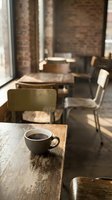 Coffee cup on wooden table in cozy cafe with brick walls and warm sunlight streaming through windows creating peaceful morning atmosphere.