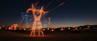 High voltage electrical transmission tower with power lines glowing against twilight sky in rural landscape for energy infrastructure concepts.