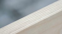 Close-up of light wood plywood edge showing layered construction and natural grain texture for carpentry and construction projects.