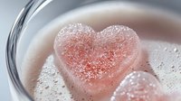 Pink heart shaped sugar cube dissolving in hot drink with foam bubbles, romantic coffee or tea time macro photography for Valentine's Day celebration.