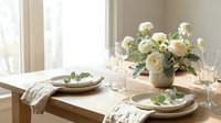 Elegant dining table setting with white roses centerpiece and neutral tableware for special occasions and home entertaining.