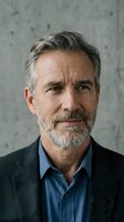 Confident mature Caucasian businessman with gray beard in dark suit jacket and blue shirt against concrete wall background for corporate marketing.