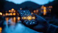 Glowing smartphone screen in hands at night with magical sparkles and bokeh lights reflecting on water surface against mountain landscape background.