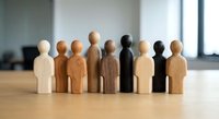 Diverse wooden figurines representing multicultural team unity and inclusion concepts for corporate diversity training and human resources materials.
